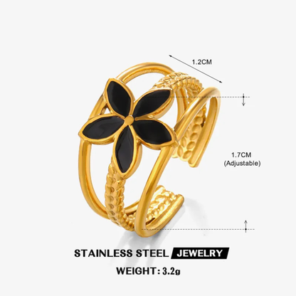 Gold ring with black flower design and measurements on a white background