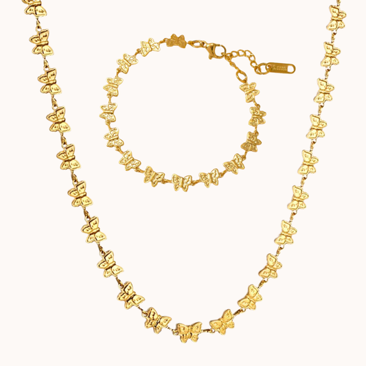 Gold butterfly necklace and bracelet set on a white background