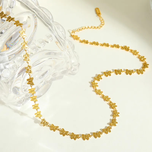 Gold necklace with floral designs on a white background