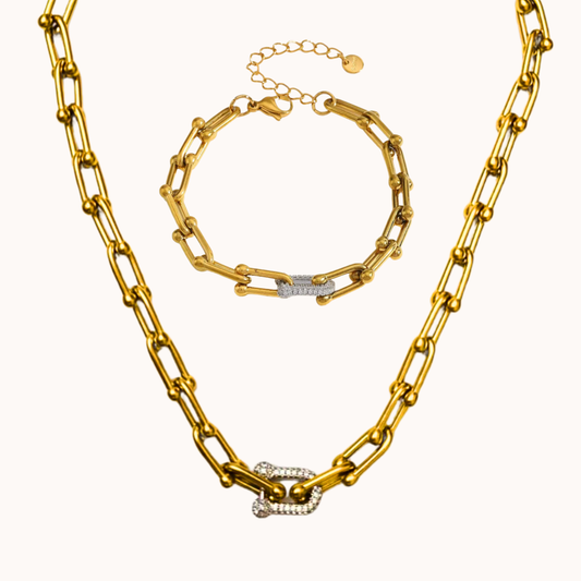 Gold chain necklace and bracelet set on a white background