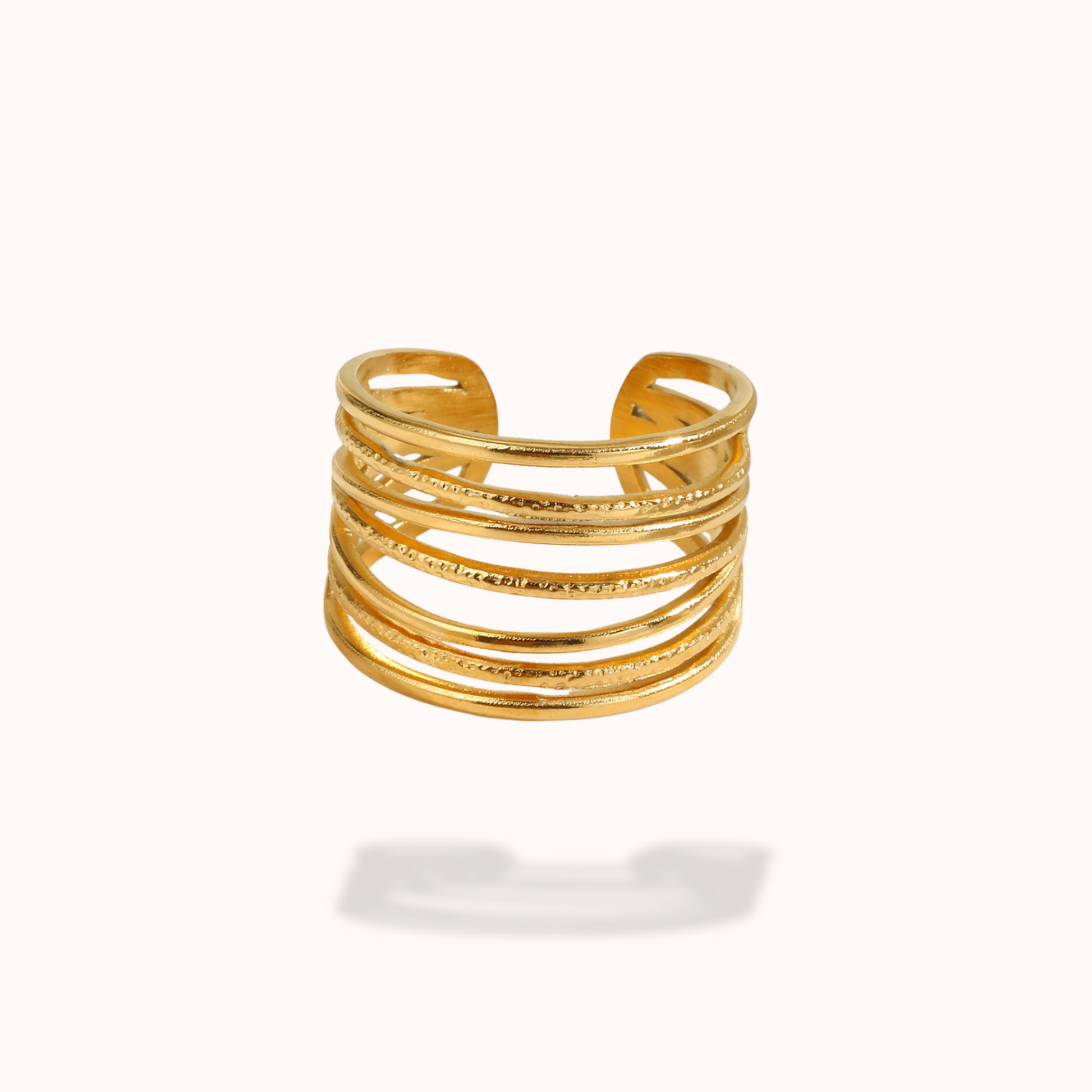 Gold ring with multiple stacked bands on a white background