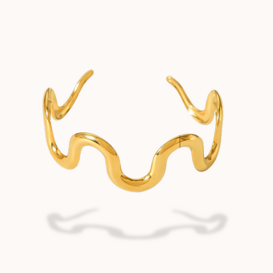 Gold wavy bracelet on a white background