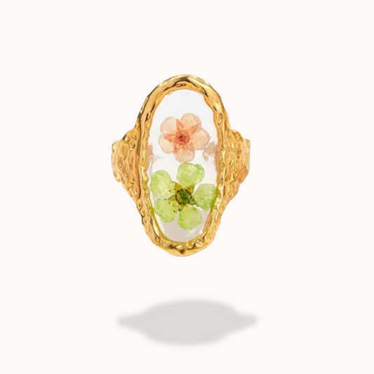 Gold ring with floral design on a white background