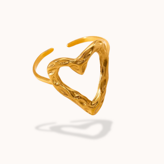 Gold heart-shaped ring on a white background