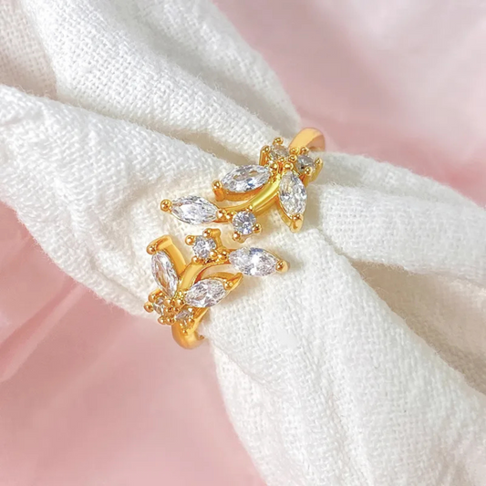 Gold earring with clear stones on a white fabric background