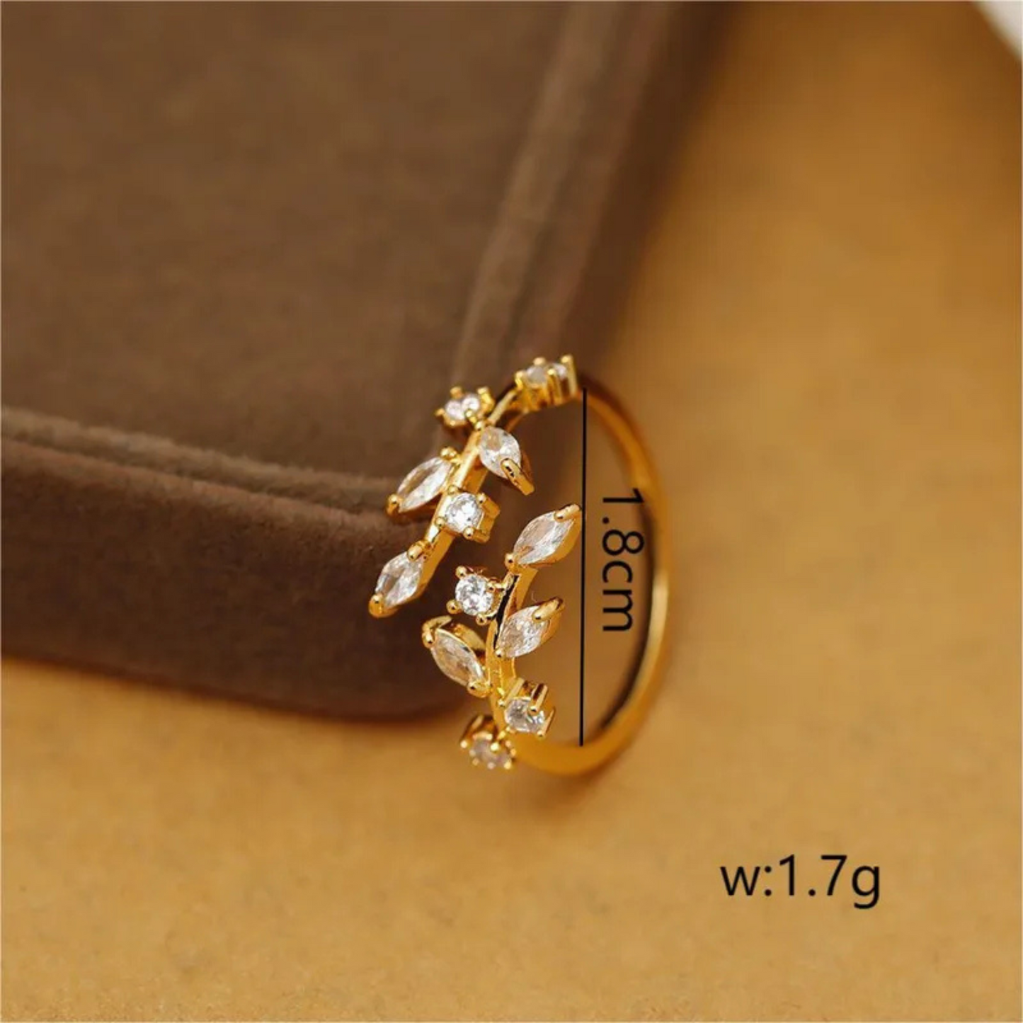 Gold earring with clear stones on a brown background