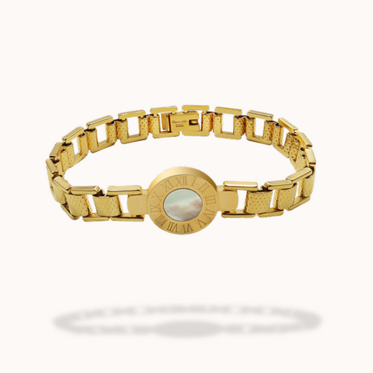 Gold bracelet with a central circular design on a white background