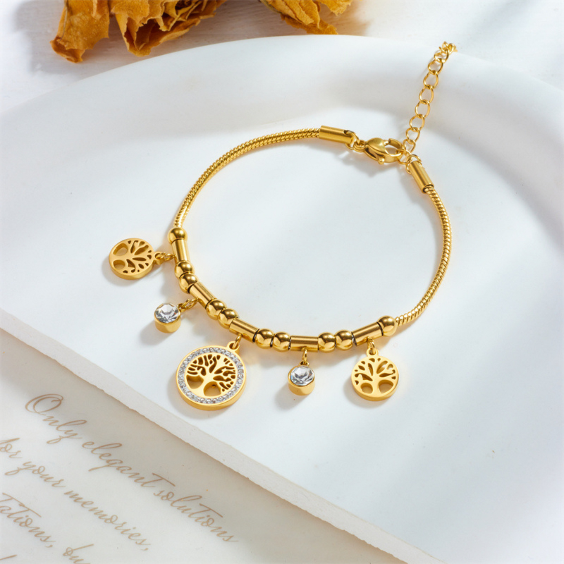 Gold bracelet with charms on a white surface
