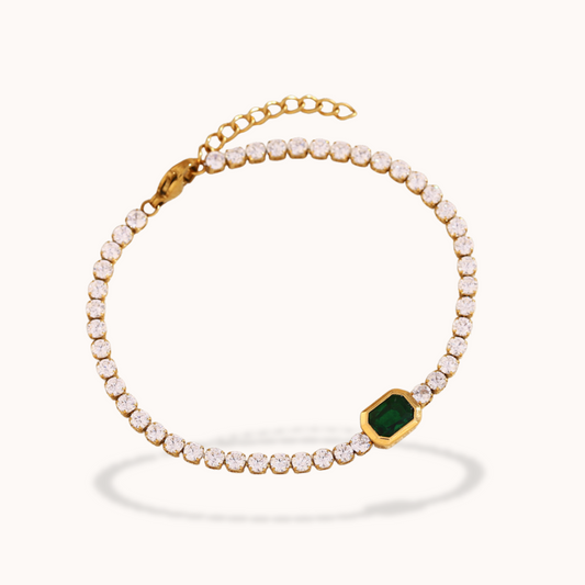 Gold Tennis bracelet with green gemstone on a white background