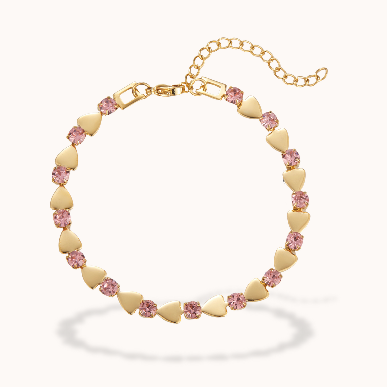 Bracelet with pink heart-shaped beads and gold chain on a white background