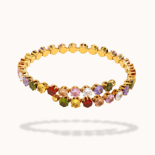 Gold bracelet with multicolored gemstones on a white background