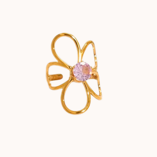 Gold flower-shaped ring with a pink gemstone on a white background