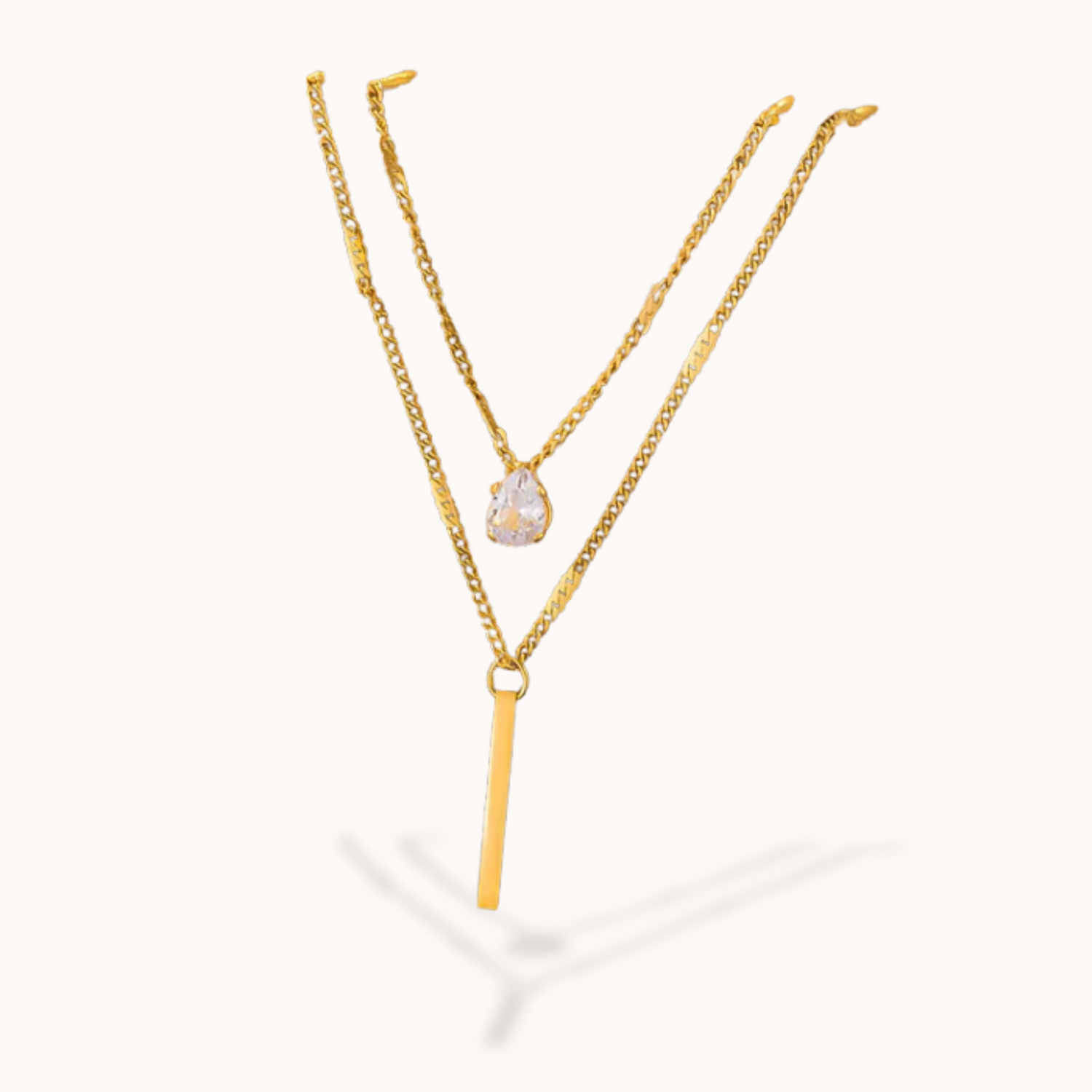 Gold necklace with a pear-shaped pendant on a white background