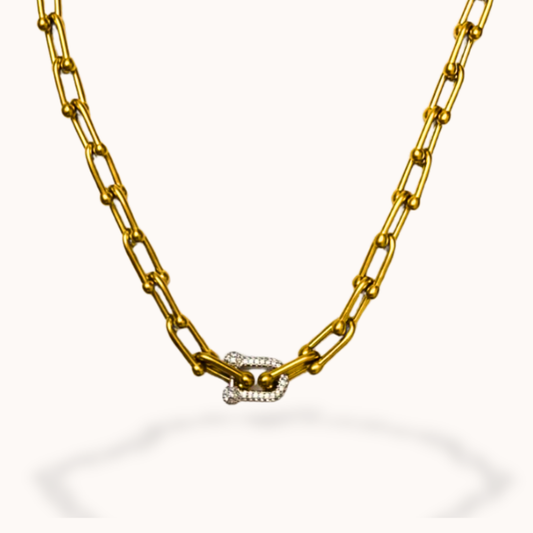 Gold chain necklace with a diamond clasp on a white background