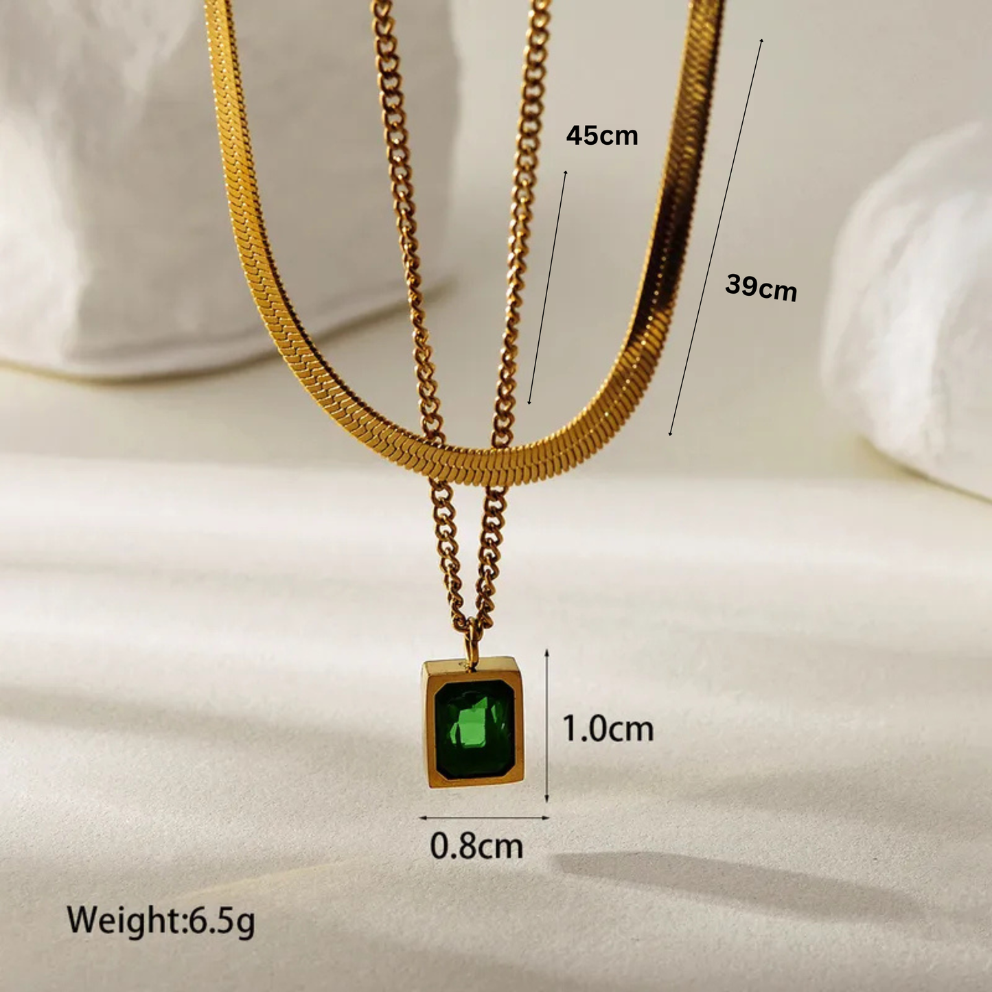 Gold necklace with a green gemstone pendant, shown with measurements on a white background.