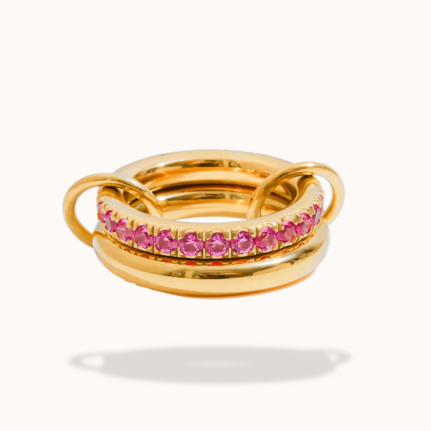 Gold ring with pink gemstones on a white background