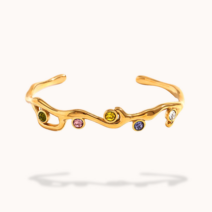Gold bracelet with embedded colorful gemstones on a white background