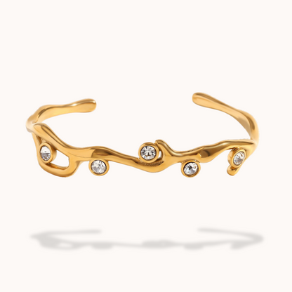 Gold bracelet with embedded crystals on a white background