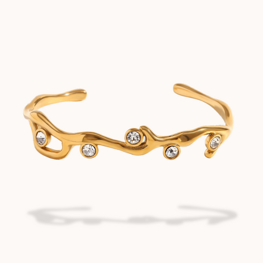Gold bracelet with embedded crystals on a white background
