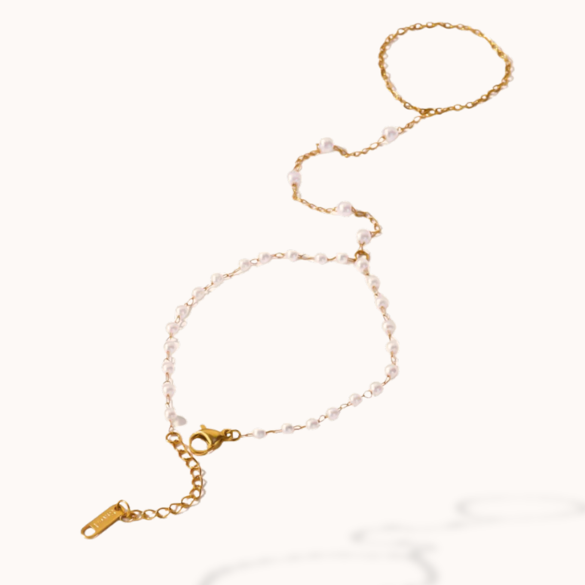 Gold bracelet with pearl-like beads on a white background