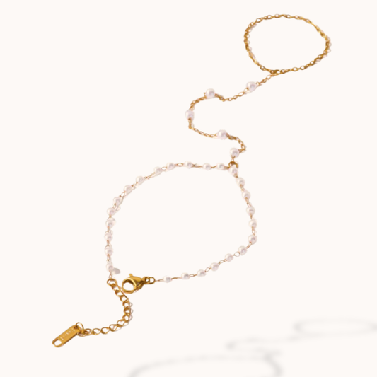 Gold bracelet with pearl-like beads on a white background