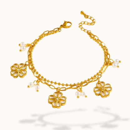 Gold bracelet with floral charms on a white background