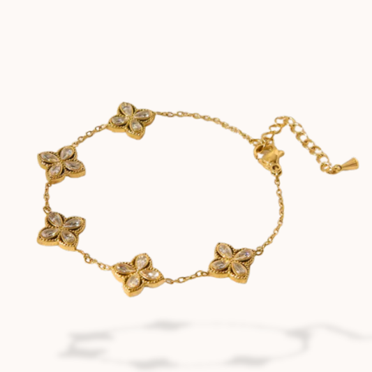 Gold bracelet with floral-shaped charms on a white background