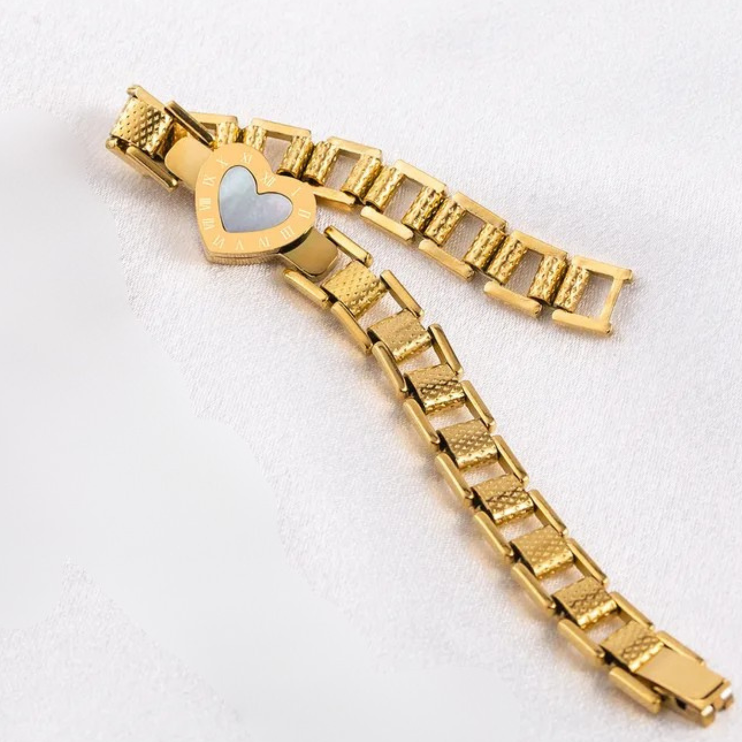 Gold bracelet with a heart-shaped clasp on a white background