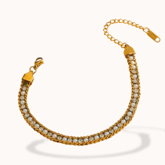 Gold bracelet with clear stones on a white background