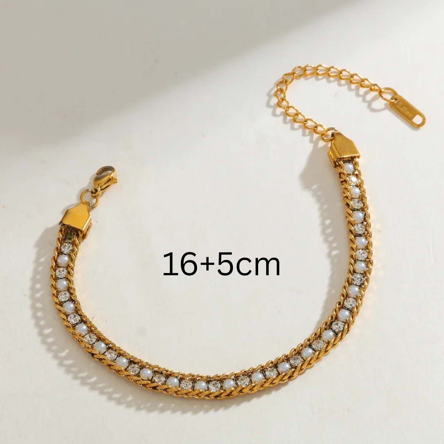 Gold bracelet with diamond-like stones on a light background