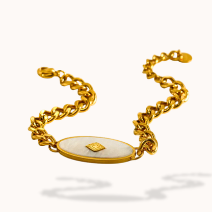 Gold bracelet with a central oval stone on a white background
