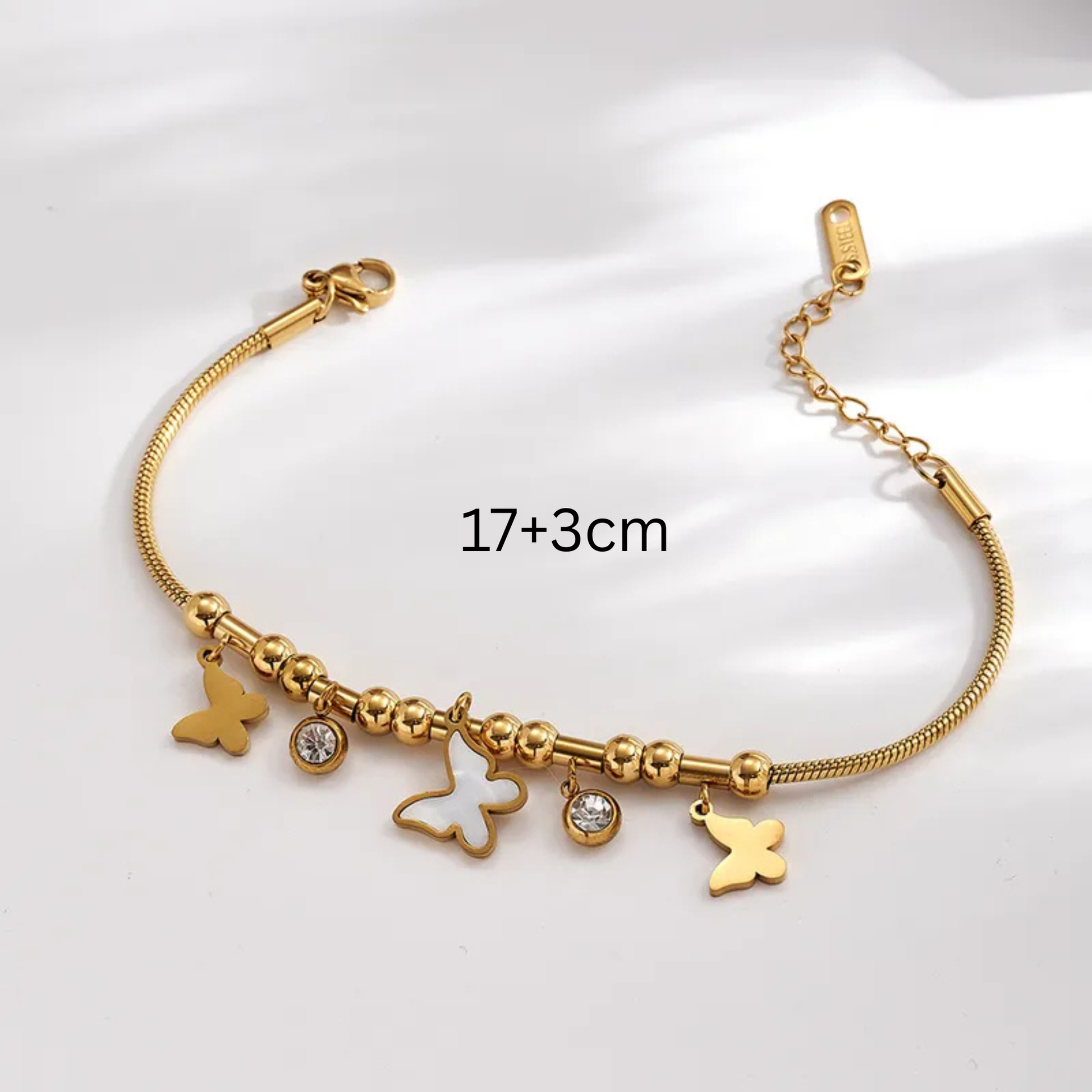 Gold bracelet with charms on a white background