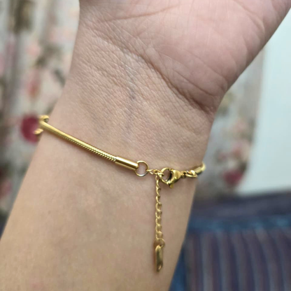 Gold bracelet on a wrist with a blurred background