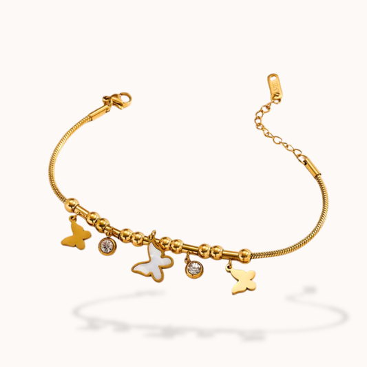 Gold bracelet with butterfly charms on a white background