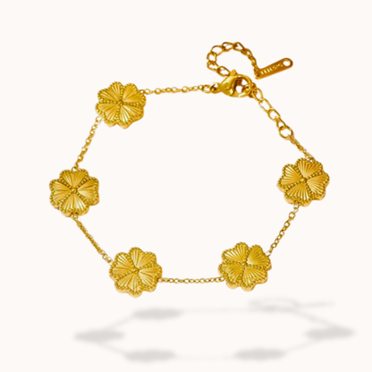 Gold bracelet with floral designs on a white background