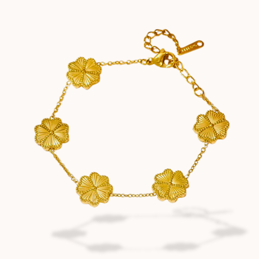 Gold bracelet with floral designs on a white background