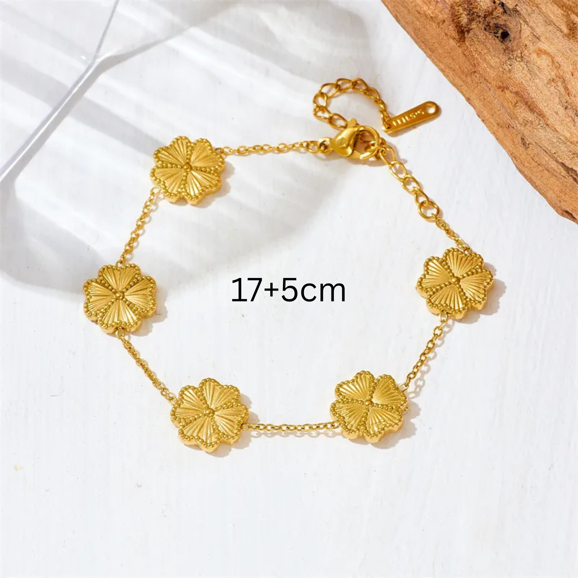Gold bracelet with floral designs on a white background