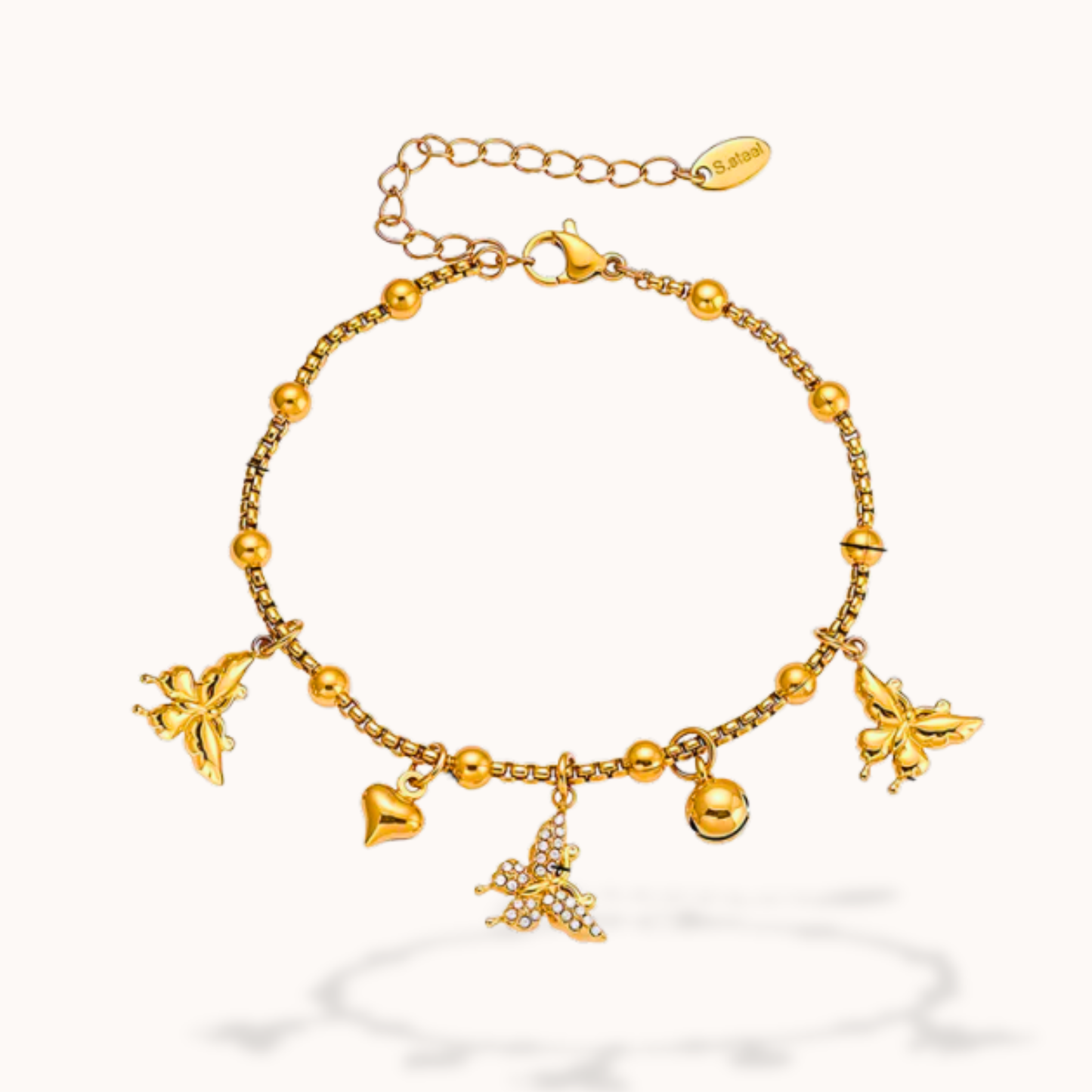 Gold bracelet with butterfly and heart charms on a white background