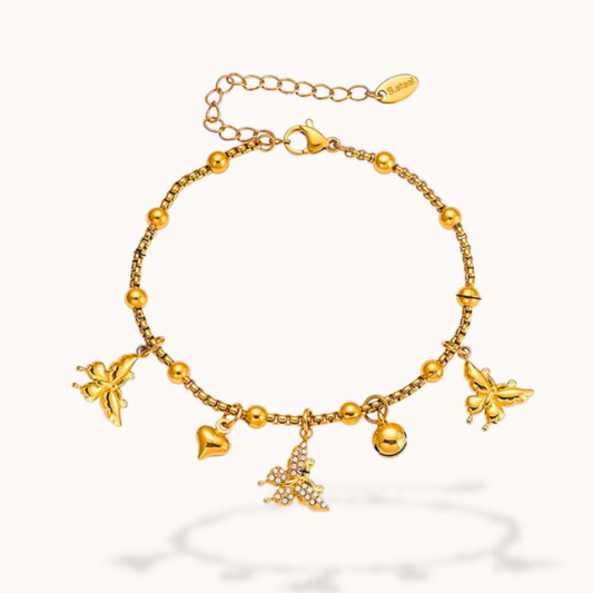 Gold bracelet with butterfly and heart charms on a white background