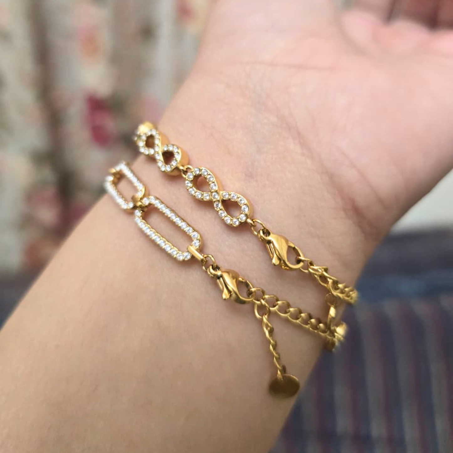 Gold chain bracelet on a wrist with a blurred background