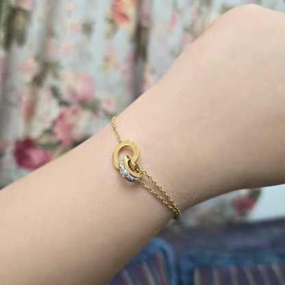 Gold bracelet on a wrist with a floral background
