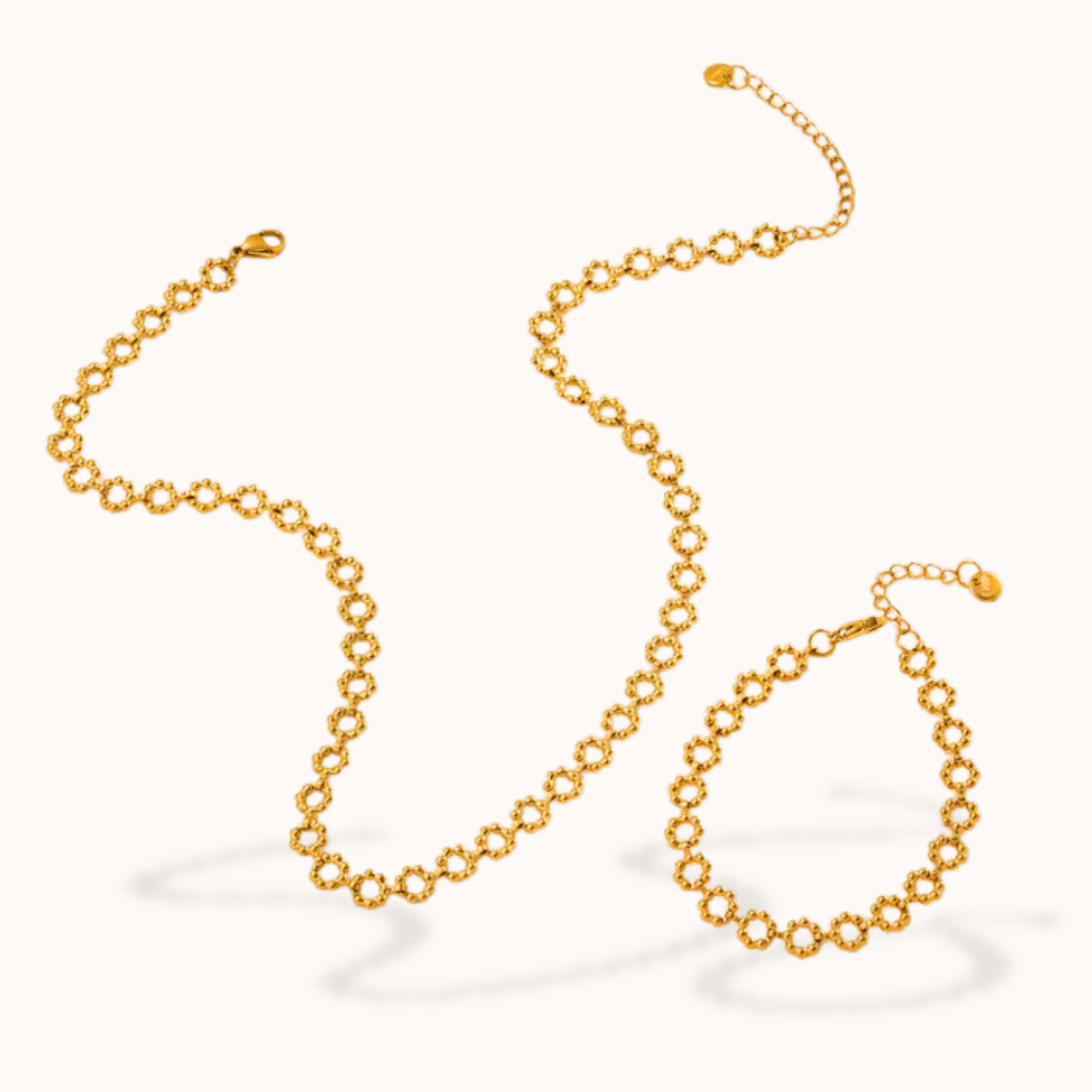 Gold chain bracelelt and necklace on a white background