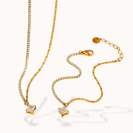 Gold necklace with star-shaped pendant on a white background