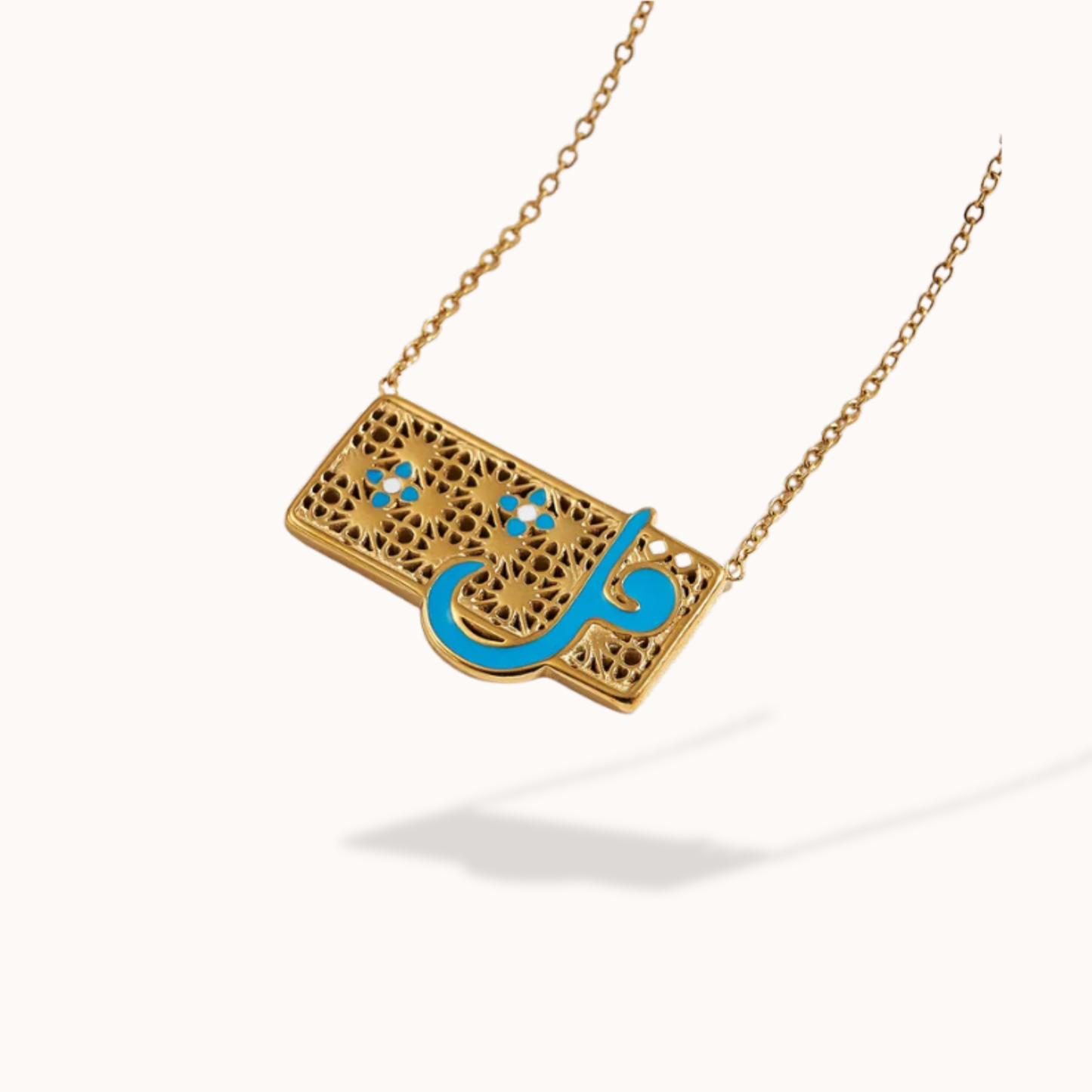 Gold necklace with a rectangular pendant featuring Arabic calligraphy in blue on a white background