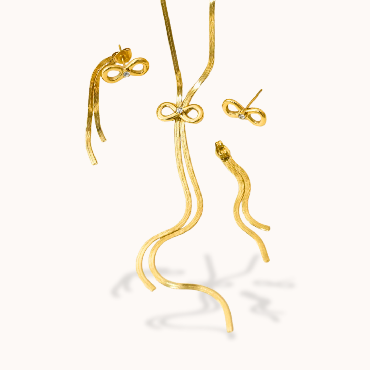 Gold jewelry set with earrings and a necklace on a white background