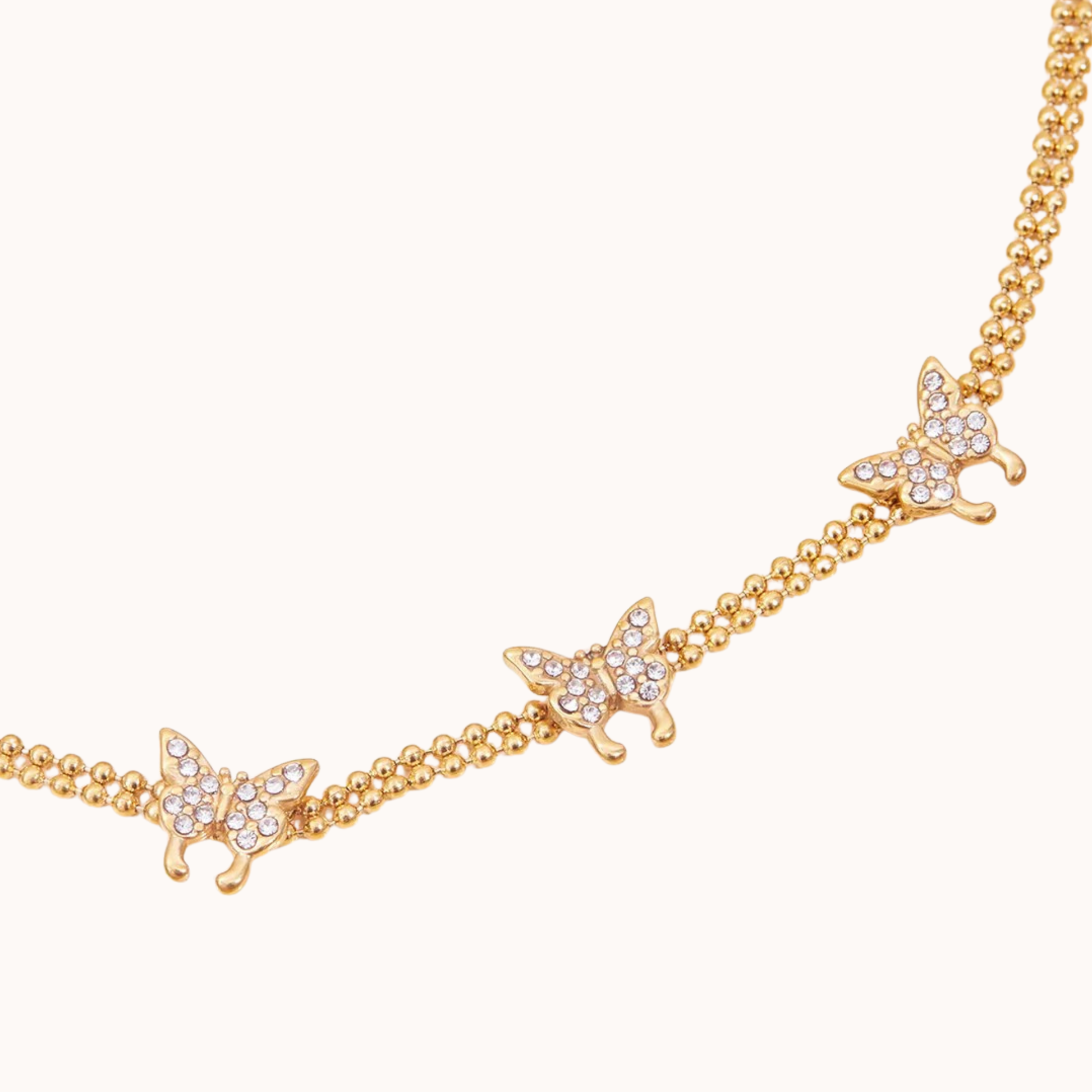 Gold butterfly necklace on a white background