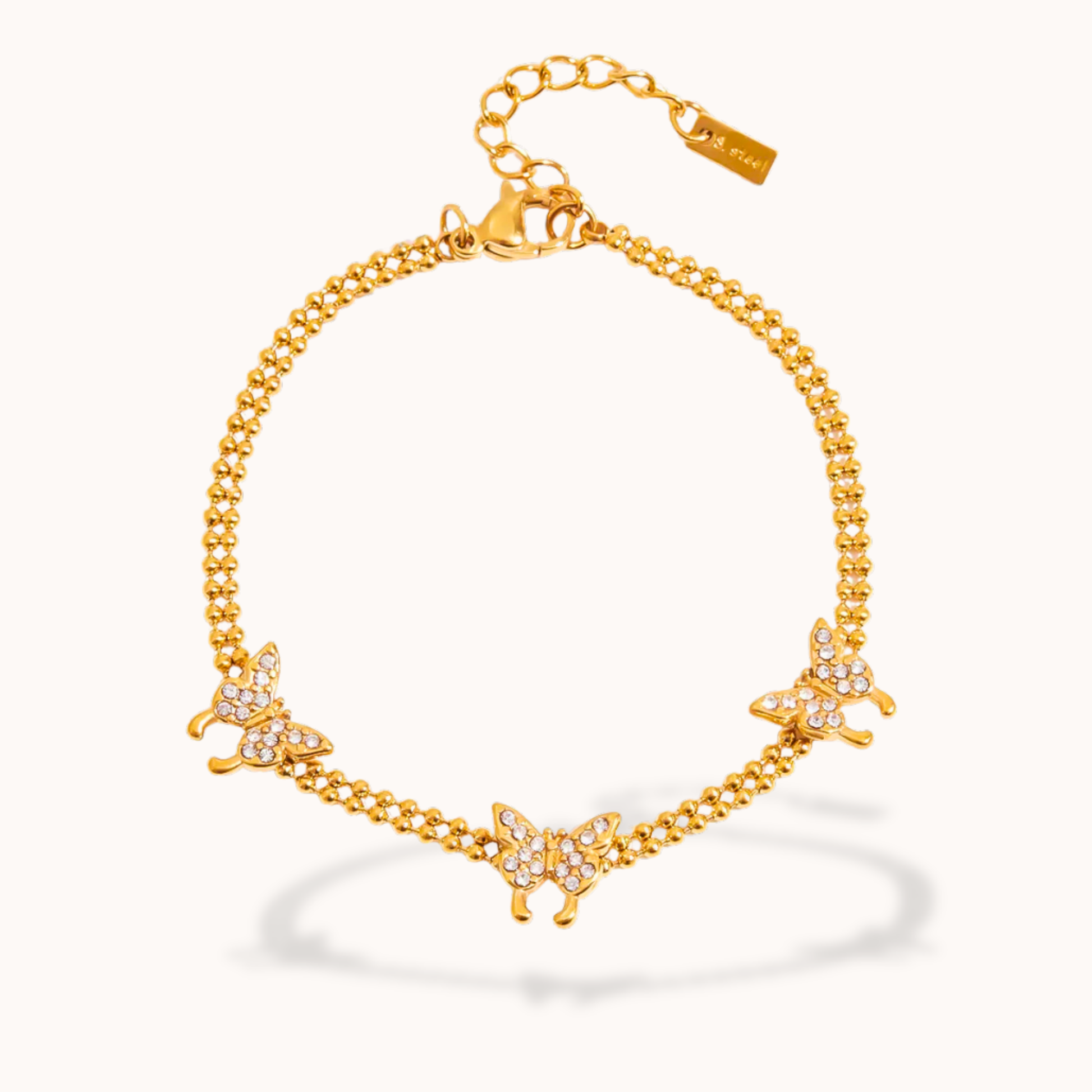 Gold bracelet with butterfly charms on a white background