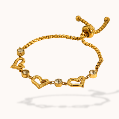 Gold bracelet with heart-shaped charms on a white background