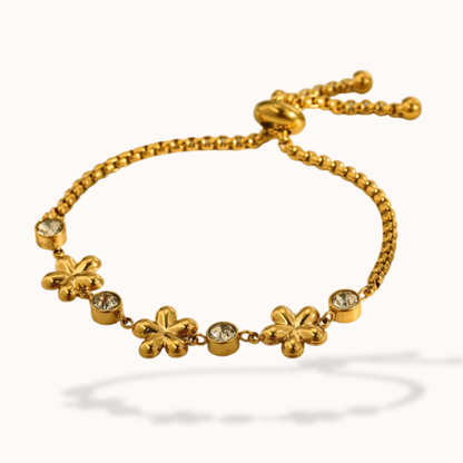 Gold bracelet with floral charms on a white background
