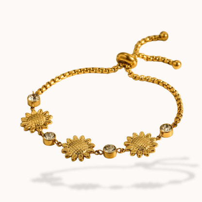 Gold bracelet with sunflower designs on a white background